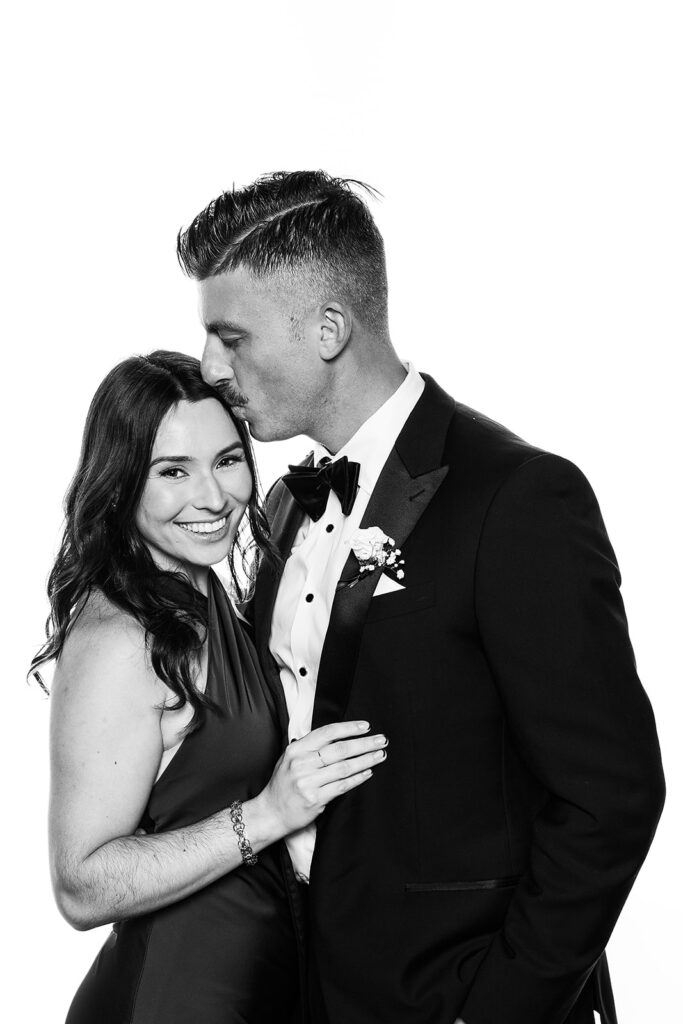 Couple in the glam booth man kissing women on temple