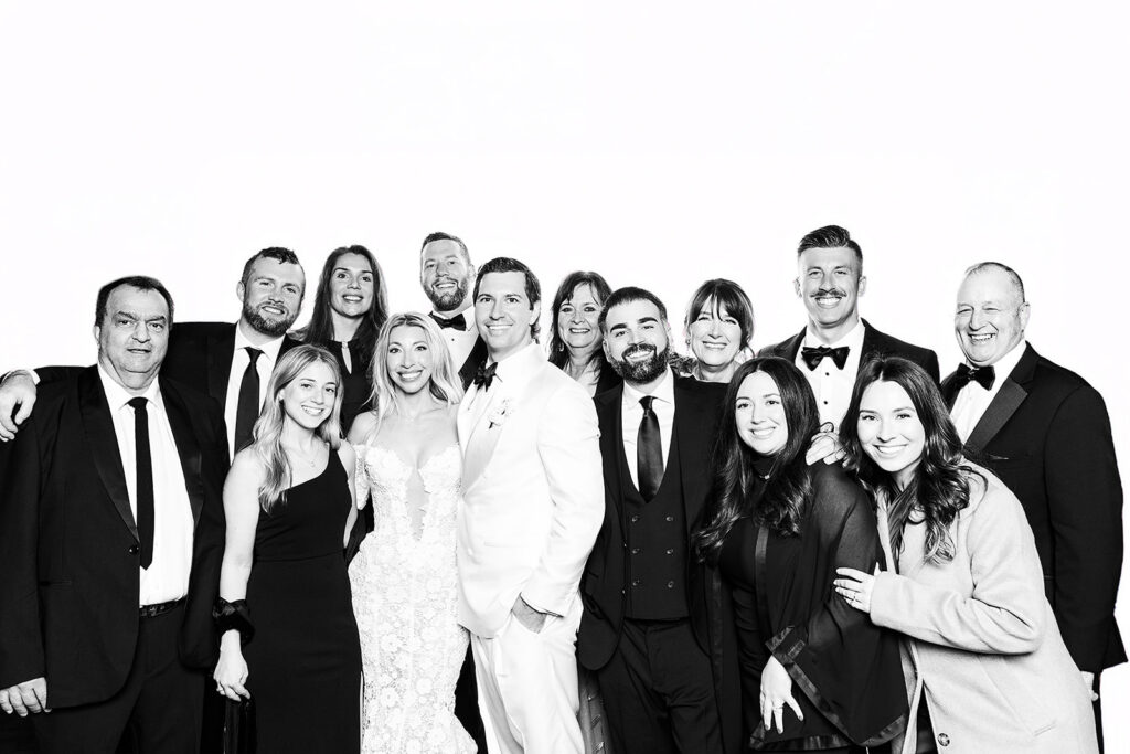group photo in a glam booth at a wedding with bride and groom
