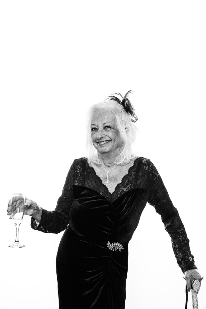 women with can and a glass of with wearing a had in glam booth